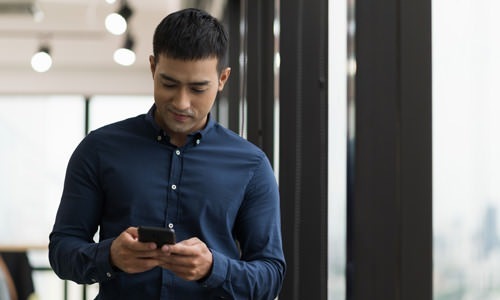 lifestyle image of a man on his smart phone outdoors